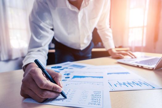Businessman accountant or financial expert analyze business report graph and finance chart at corporate office. Concept of finance economy, banking business and stock market research.