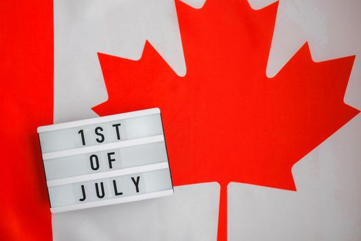 The National Flag of Canada. Lightbox with text 1ST OF JULY Canadian Flag or the Maple Leaf. Patriotism. International relations concept. Independence day. Immigration