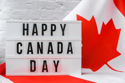 The National Flag of Canada. Lightbox with text HAPPY CANADA DAY Canadian Flag or the Maple Leaf. Patriotism. International relations concept. Independence day. Immigration