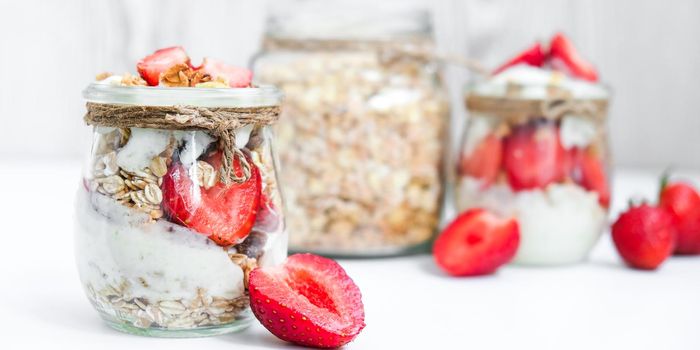 Healthy breakfast. Oatmeal Granola with greek yogurt and nuts strawberry muesli in jars on light background. Vegan, vegetarian and weight loss diet concept. Detox menu. Healthy eating food