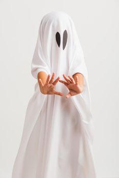 Funny Halloween Kid Concept, little cute child with white dressed costume halloween ghost scary, studio shot isolated on white background