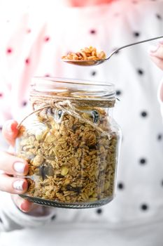 Female hands, woman eating Healthy breakfast. Oatmeal Granola muesli in jar. Vegan, vegetarian and weight loss diet concept. Detox menu. Healthy eating food