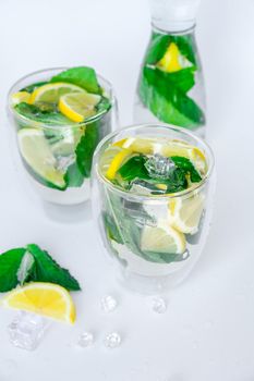 Mojito refreshing cocktail, alcohol drink. Lemonade with lemon and mint leaves on light background. Ice cubes. Summer refreshing detox drinks. Clean eating, healthy lifestyle concept, Diet. Nutrition.