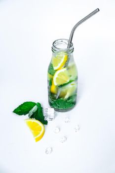 Mojito refreshing cocktail with eco metal drinking straw, alcohol drink. Lemonade with lemon and mint leaves on light background. Ice cubes. Summer refreshing detox drinks. Clean eating, healthy lifestyle concept, Diet. Nutrition.