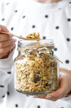 Female hands, woman eating Healthy breakfast. Oatmeal Granola muesli in jar. Vegan, vegetarian and weight loss diet concept. Detox menu. Healthy eating food