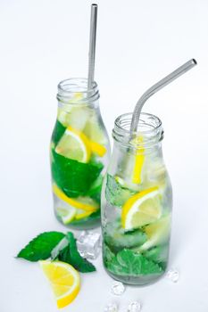 Mojito refreshing cocktail with eco metal drinking straw, alcohol drink. Lemonade with lemon and mint leaves on light background. Ice cubes. Summer refreshing detox drinks. Clean eating, healthy lifestyle concept, Diet. Nutrition.