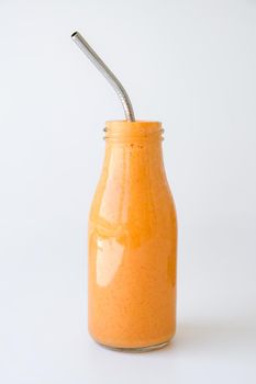 Seasonal pumpkin carrot smoothie drink detox with eco metal drinking straw. Glass bottle of orange smoothie or juice. Clean eating, weight loss, healthy dieting food concept. Fruit vegetable drink fitness