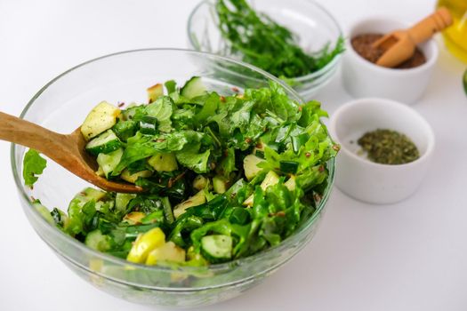 Salad of fresh green vegetables and herbs. Cooking healthy diet or vegetarian food. Step by step recipe. Healthy eating. Ingredients for salad. Raw food concept. A variety of organic fruits and vegetables with avocado. Vegan menu. Fresh spinach and green onion leaves, arugula. Flax seeds