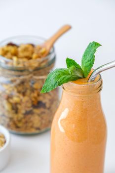 Seasonal pumpkin carrot smoothie drink detox with eco metal drinking straw Glass jar granola muesli oatmeal breakfast. Orange smoothie. Clean eating, weight loss, healthy dieting food concept Fruit vegetable drink fitness