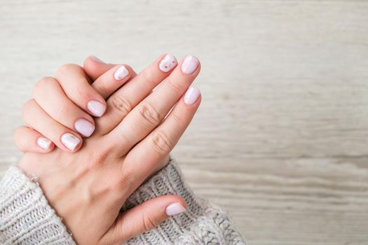 Closeup elegant pastel natural modern design manicure. Female hands. Gel nails. Nude manicure. Beige color. Clean skin. Spa salon, advertisement. Skin care. Beauty. Nail care. Beauty treatment. Copy space