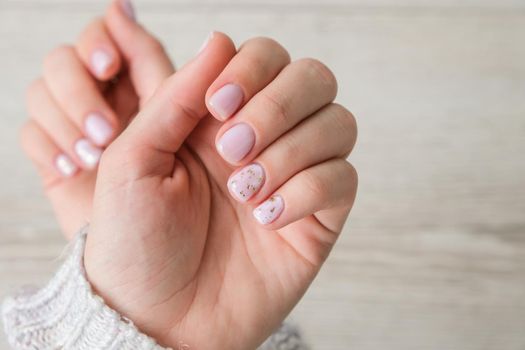 Closeup elegant pastel natural modern design manicure. Female hands. Gel nails. Nude manicure. Beige color. Clean skin. Spa salon, advertisement. Skin care. Beauty. Nail care. Beauty treatment. Copy space