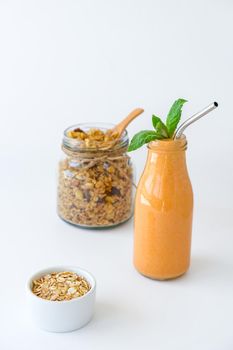 Seasonal pumpkin carrot smoothie drink detox with eco metal drinking straw Glass jar granola muesli oatmeal breakfast. Orange smoothie. Clean eating, weight loss, healthy dieting food concept Fruit vegetable drink fitness