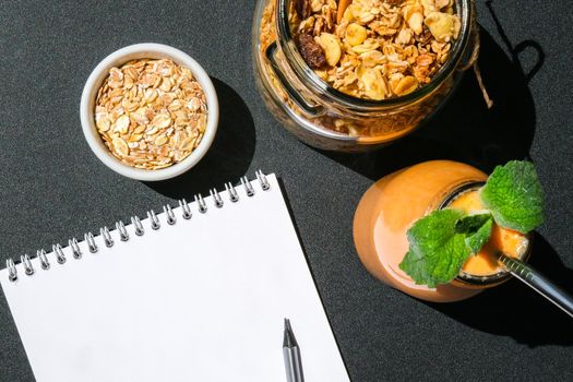 Seasonal pumpkin carrot smoothie drink detox with eco metal drinking straw Glass jar granola muesli oatmeal breakfast. Paper note. Clean eating, weight loss, healthy dieting food concept Fruit vegetable drink fitness