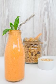 Seasonal pumpkin carrot smoothie drink detox with eco metal drinking straw Glass jar granola muesli oatmeal breakfast. Orange smoothie. Clean eating, weight loss, healthy dieting food concept Fruit vegetable drink fitness