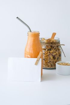 Seasonal pumpkin carrot smoothie drink detox with eco metal drinking straw Glass jar granola muesli oatmeal breakfast. Paper note. Clean eating, weight loss, healthy dieting food concept Fruit vegetable drink fitness