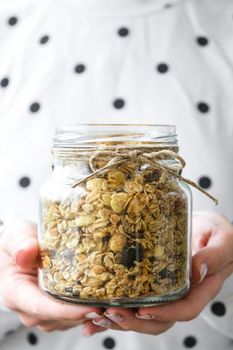 Female hands, woman eating Healthy breakfast. Oatmeal Granola muesli in jar. Vegan, vegetarian and weight loss diet concept. Detox menu. Healthy eating food