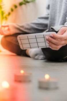 Young millennial blonde woman doing yoga exercise watching tutorial lesson on mobile phone stretching fitness at balcony home. Mindfulness meditation. The concept of online training. Video lessons. Self-isolation is beneficial. Exercise for Lose weight, increase flexibility And tighten the shape. Young slim athletic girl practices yoga at home in online lessons.