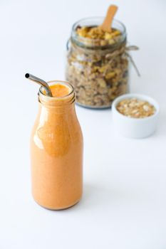 Seasonal pumpkin carrot smoothie drink detox with eco metal drinking straw Glass jar granola muesli oatmeal breakfast. Orange smoothie. Clean eating, weight loss, healthy dieting food concept Fruit vegetable drink fitness