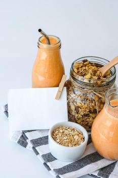 Seasonal pumpkin carrot smoothie drink detox with eco metal drinking straw Glass jar granola muesli oatmeal breakfast. Paper note. Clean eating, weight loss, healthy dieting food concept Fruit vegetable drink fitness