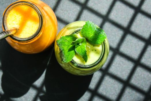 Seasonal Matcha green vegan smoothie with chia seeds and mint pumpkin carrot smoothie drink detox Breakfast. Clean eating, weight loss, healthy dieting food concept Fruit vegetable drink fitness. Trendy shadows