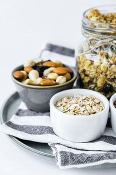 Healthy breakfast. Oatmeal Granola with greek yogurt and nuts banana muesli in jars on light background. Vegan, vegetarian and weight loss diet concept. Detox menu. Healthy eating food