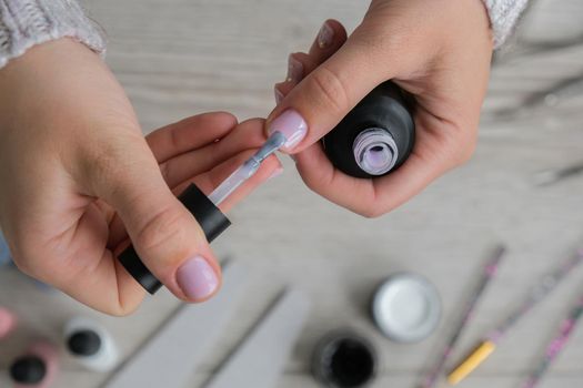 Modern female nude design manicure. Nail care, Self care. Do manicure by yourself while staying at home. Female hands and manicure tools. Spa salon. Professional Hardware Manicure. Procedure for the preparation of nails. Cuticle Pusher Remover. Nail file scissors