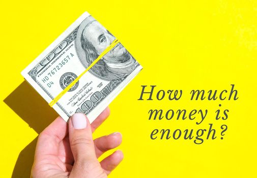 HOW MUCH MONEY IS ENOUGH Quote Female hand holding dollars close up. Money currency. Online shopping. Giving money. Business budget of wealth and prosperity finance, buy coin, economic, exchange payday. Salary investment savings