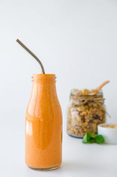 Seasonal pumpkin carrot smoothie drink detox with eco metal drinking straw Glass jar granola muesli oatmeal breakfast. Orange smoothie. Clean eating, weight loss, healthy dieting food concept Fruit vegetable drink fitness