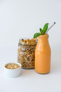 Seasonal pumpkin carrot smoothie drink detox with eco metal drinking straw Glass jar granola muesli oatmeal breakfast. Orange smoothie. Clean eating, weight loss, healthy dieting food concept Fruit vegetable drink fitness