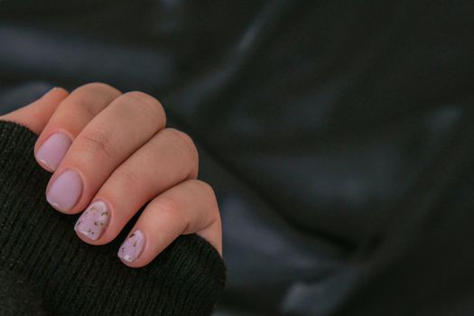 Closeup elegant pastel natural modern design manicure on fabric silk background. Female hands. Gel nails. Nude manicure. Beige color. Clean skin. Spa salon, advertisement. Skin care. Beauty. Nail care. Beauty treatment. Copy space