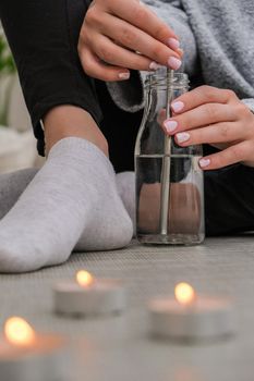 Young millennial blonde woman drinking water from eco bottle with metal reusable straw tube and doing yoga exercise stretching fitness at balcony home. Mindfulness meditation. The concept of healthy nutrition, environmental friendliness and zero waste. Self-isolation is beneficial