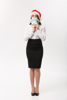 Christmas and finance concept - Young business woman showing money closing her face with surprise expression.
