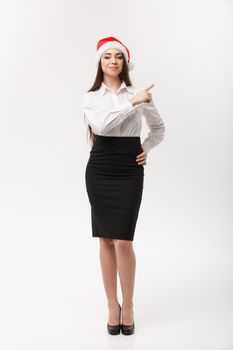 Business Concept - Modern caucasian business woman in the white studio background pointing finger onside presenting product.