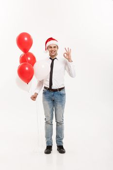 Christmas Concept - Handsome happy Business man walking with red balloon celebrate merry christmas and happy new year wear santa hat.