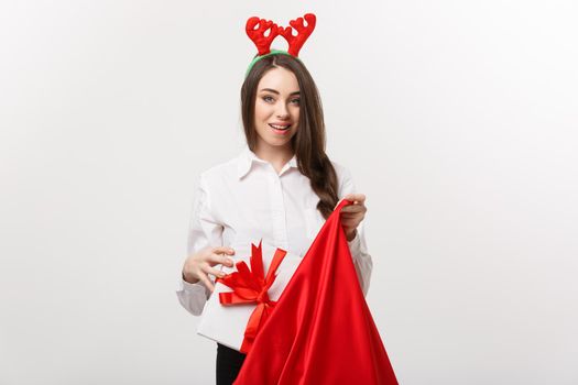 Christmas Concept - Young beautiful business woman happy with present in santa bag.