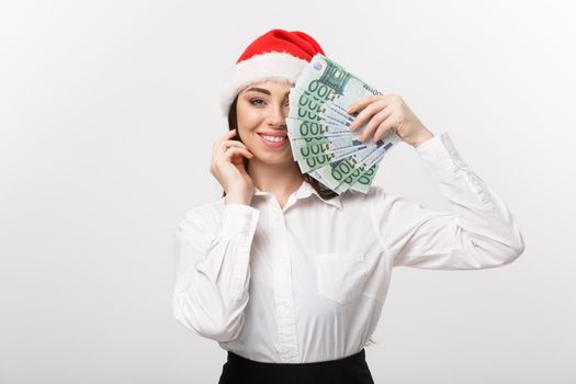 Christmas and finance concept - Young business woman showing money closing her face with surprise expression.