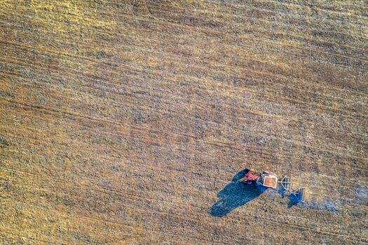 Aerial view from drone of field processing with the tractor. Agriculture processing of fields. Top view
