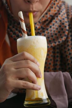 young women drinking banana milk shake at cafe .