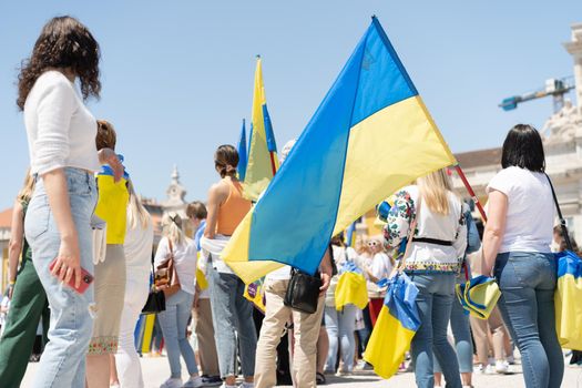 Portugal, Lisbon April 2022: The demonstration on Commerce Square in support of Ukraine and against the Russian aggression. Protesters against Russia's war Many people with Ukrainian flags. Crowd