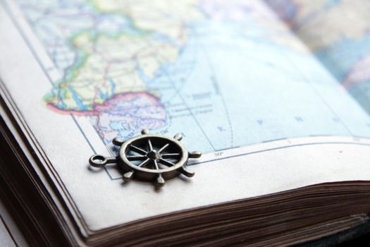 Summer travel concept. Smoll nautical steering wheel and map.