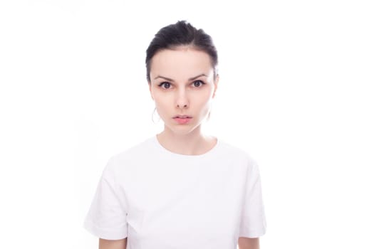brunette woman in white t-shirt, white studio background. High quality photo