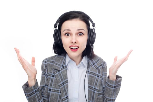 surprised woman in office suit listening to music in big full size headphones. High quality photo