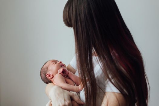 Mom holds the baby in her arms lifestyle . Mother's love for her son. A newborn baby. Mother and child relationship.