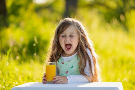 girl with a glass of orange juice in nature