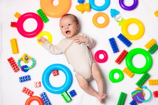 The baby is lying in toys . An article about children's toys. A selection of toys for kids. Designer