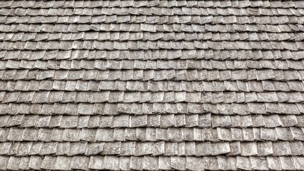 Weathered wooden shingles on a roof. wooden roof tile of old house