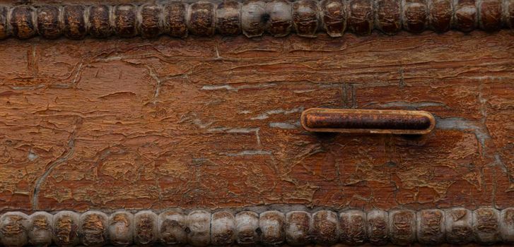 banner with old cracked wooden chest of drawers. background with brown cracks on a wooden chest of drawers with a rusty handle. soft focus