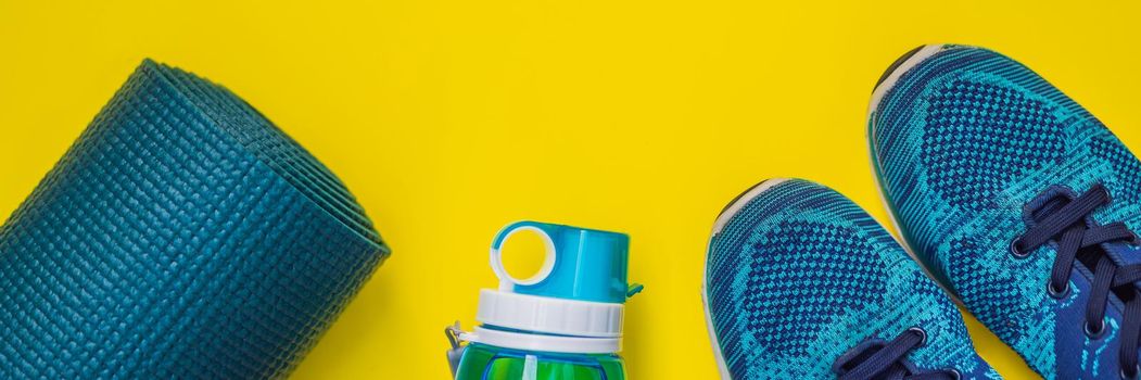 BANNER, LONG FORMAT Everything for sports turquoise, blue shades on a yellow background. Yoga mat, sport shoes sportswear and bottle of water. Concept healthy lifestyle, sport and diet. Sport equipment. Copy space.