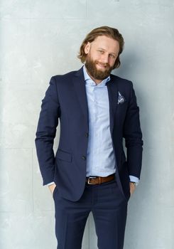 a handsome brutal bearded and long-haired man, a stylish businessman on a white background. High quality photo