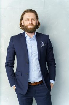 a handsome brutal bearded and long-haired man, a stylish businessman on a white background. High quality photo